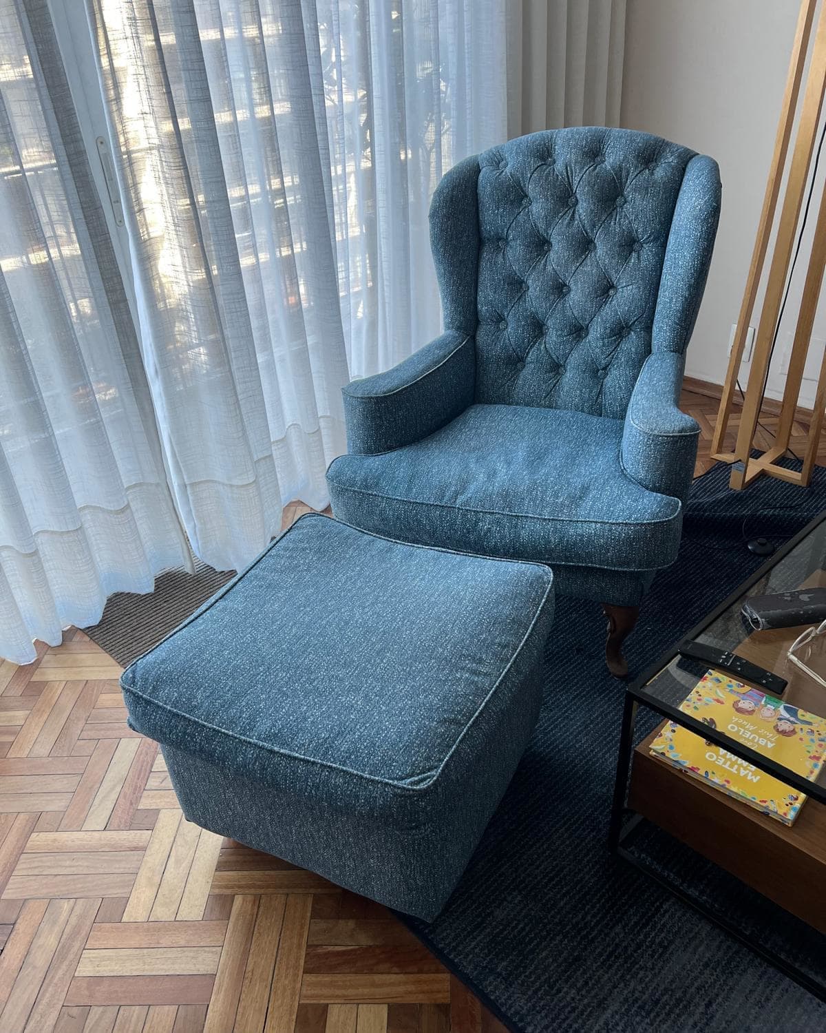 Sillón orejero capitoné con puff