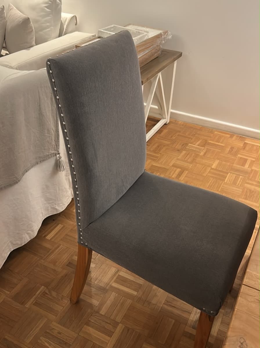 Sillas tapizadas en gris con detalle de tachas plateadas y patas de madera…