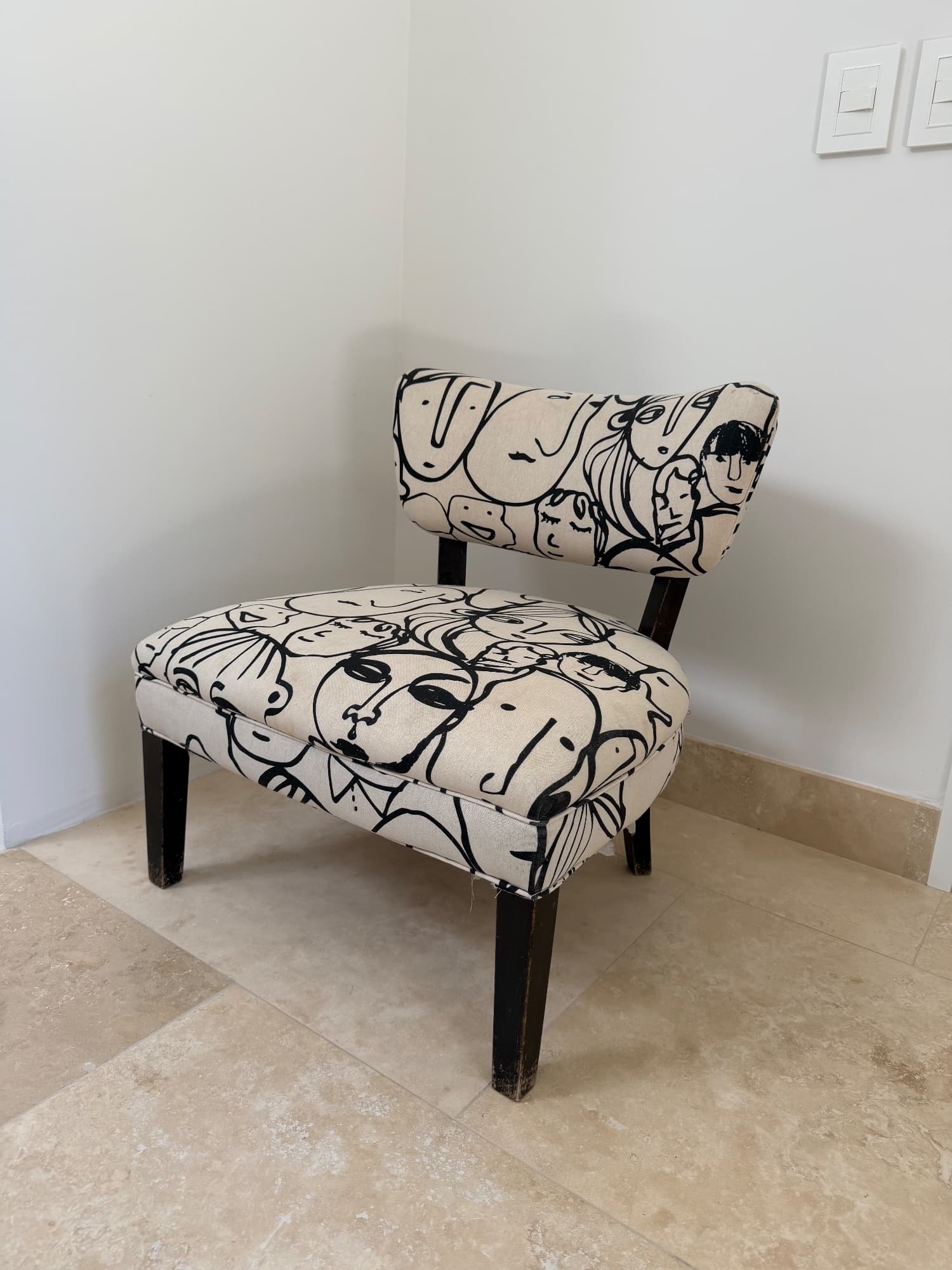 Silla tapizada con estampado de rostros